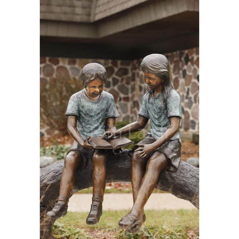 Bronze Statue of a Boy and Girl Children Reading a Book on a Log