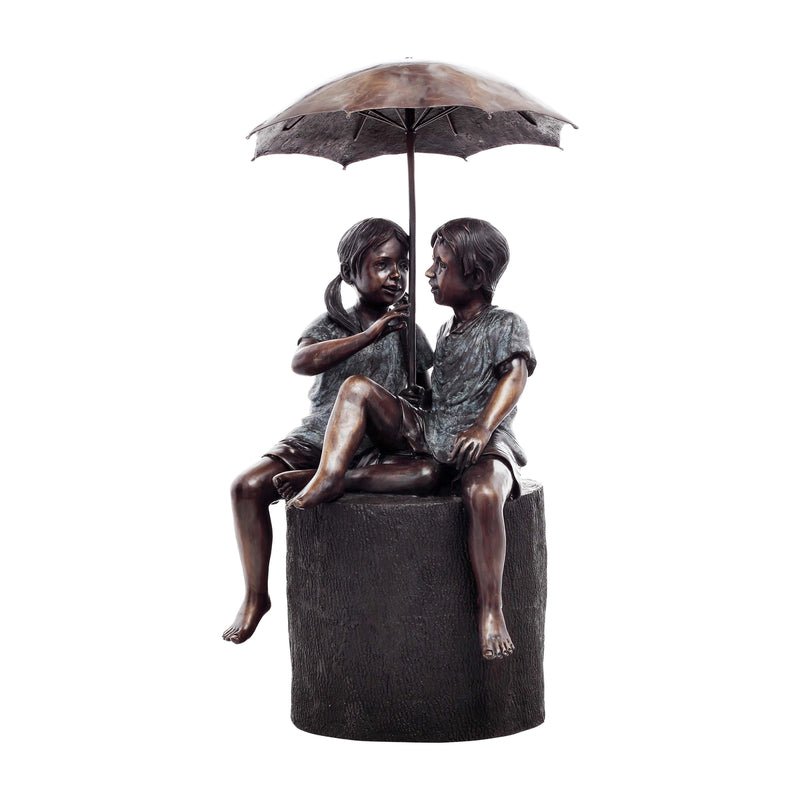 bronze statue of boy and girl under umbrella fountain