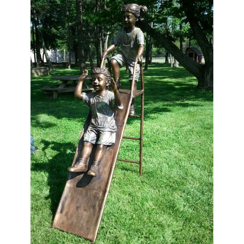 Bronze Statue of Children Playing on Slide at Park
