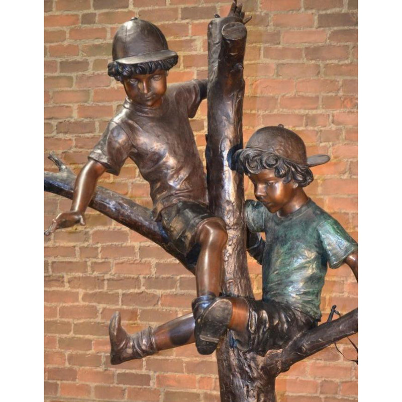 bronze statue of two boys playing in tree with dog
