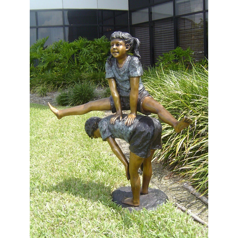 children playing leap frog bronze statue