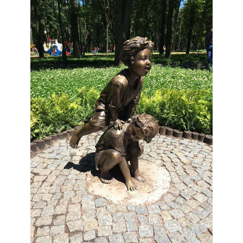 bronze statue of boys playing leap frog